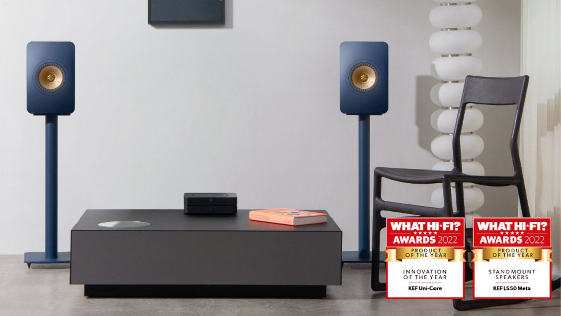 Home theatre setup with KEF speakers and equipment on a table, featuring awards.