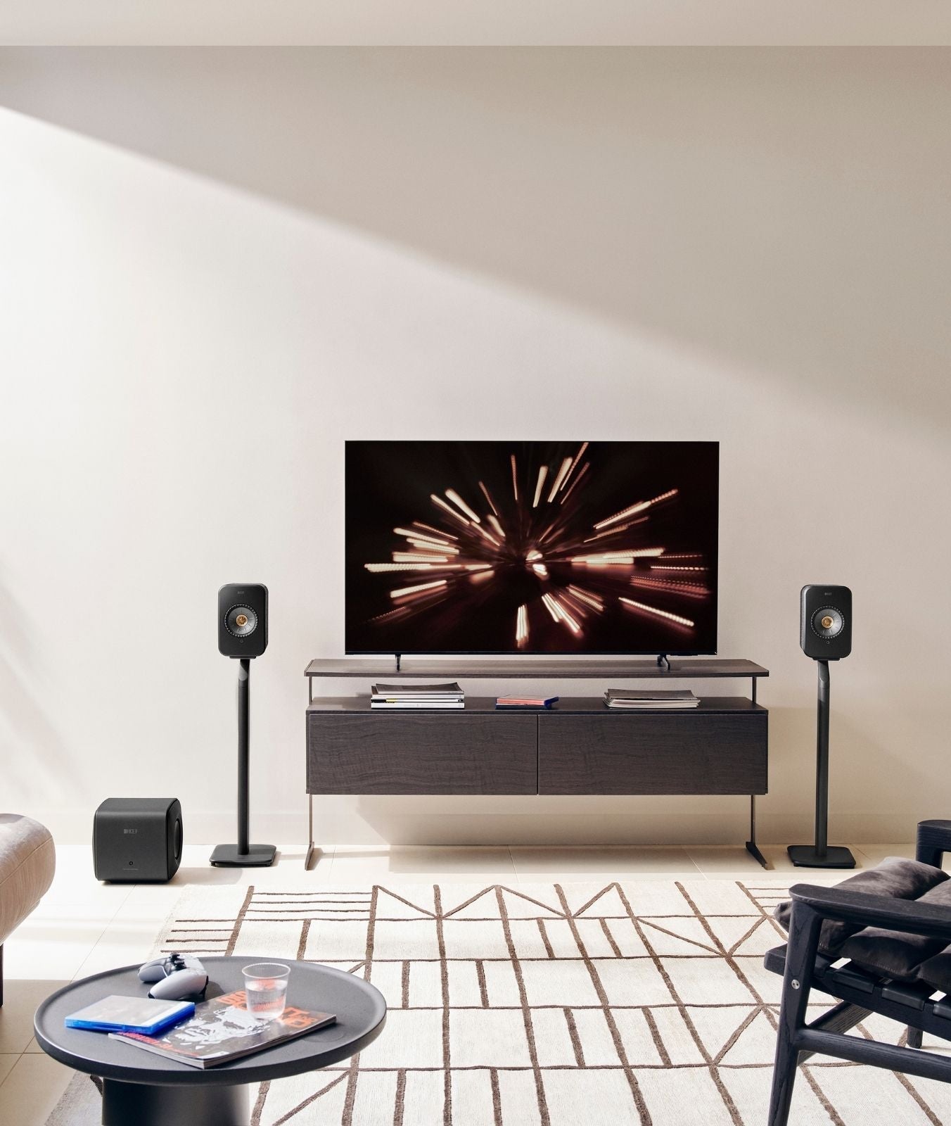 Modern living room with a television, LSX II speakers, and a coffee table.
