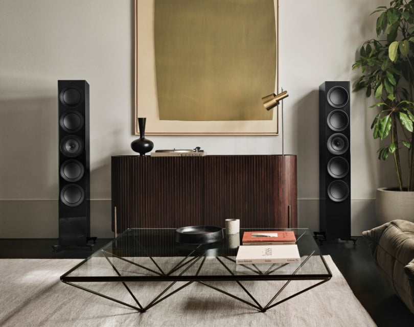 Pair of black R11 floorstanding speakers in living room.